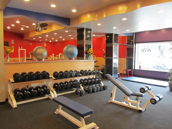 Rows of free weights arranged on racks in a gym